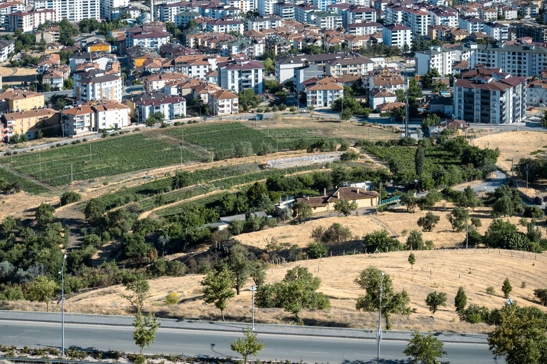 Türkiye'de bir şehir merkezinde imara açık boş arsa ve arkasında yükselen konut projeleri
